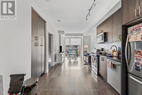 A modern kitchen with a refrigerator on the right side.