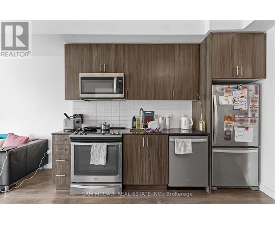 A kitchen with a microwave, oven, and refrigerator.