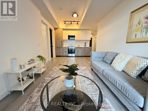 A modern living room with a grey sofa and a glass coffee table.