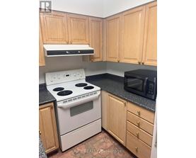 A kitchen with wooden cabinets and a black countertop.