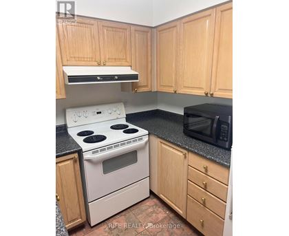 A kitchen with wooden cabinets and a black countertop.