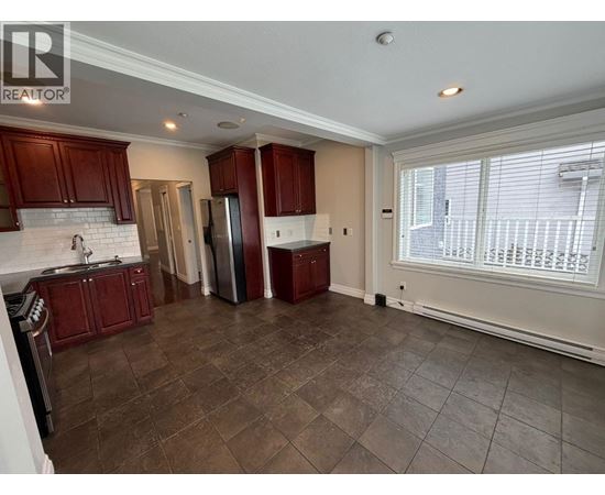 A kitchen with brown cabinets and a tiled floor.