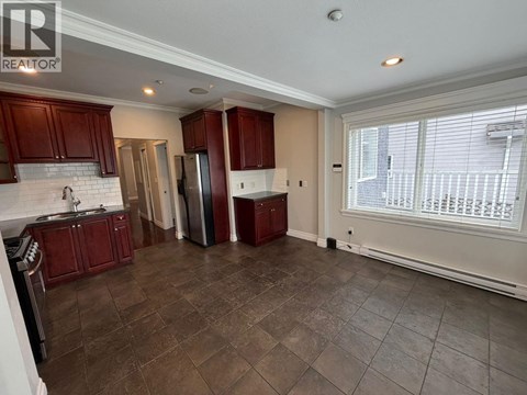 A kitchen with brown cabinets and a tiled floor.