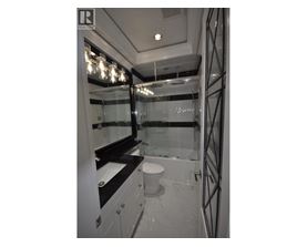 A bathroom with a toilet, sink, and mirror.
