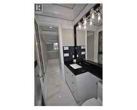 A bathroom with a marble countertop and a large mirror.