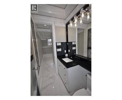 A bathroom with a marble countertop and a large mirror.