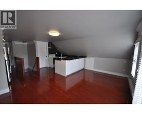 A room with wooden floors and a white kitchen island.