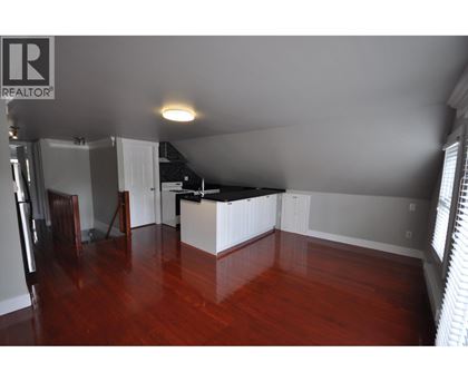 A room with wooden floors and a white kitchen island.