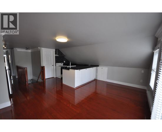 A room with wooden floors and a white kitchen island.