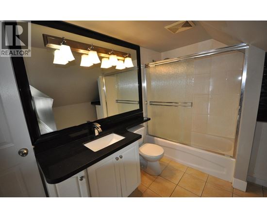 A bathroom with a sink, toilet, and shower.