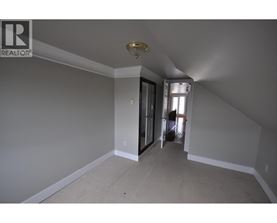 A room with a carpeted floor and a sliding glass door leading to a hallway.
