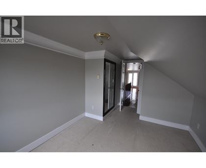 A room with a carpeted floor and a sliding glass door leading to a hallway.