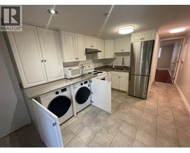 A kitchen with white cabinets and a stainless steel refrigerator.