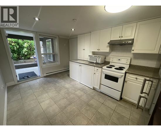 A kitchen with white appliances and cabinets.
