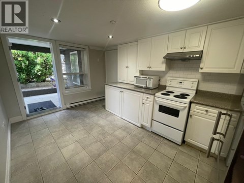 A kitchen with white appliances and cabinets.