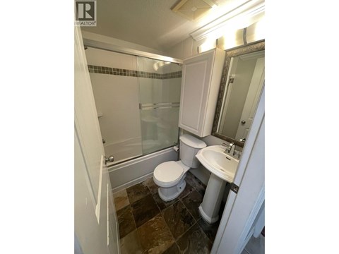 A bathroom with a toilet, sink, and shower.