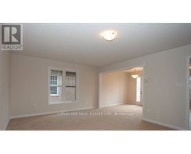 A realtor logo is on the wall in a room with a window.