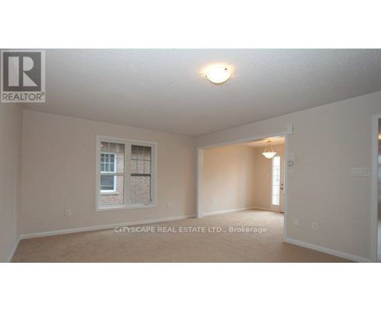 A realtor logo is on the wall in a room with a window.