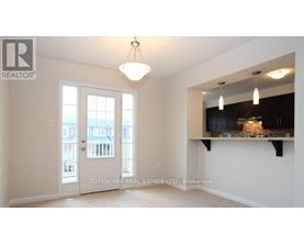 A real estate listing image of a room with a large window and a view of a building outside.