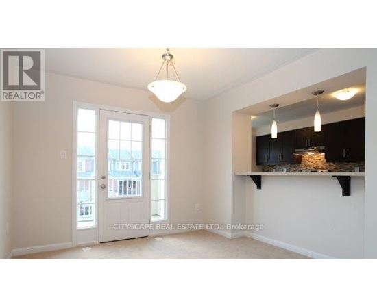 A real estate listing image of a room with a large window and a view of a building outside.