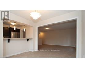 A spacious room with a large open doorway leading to another room.