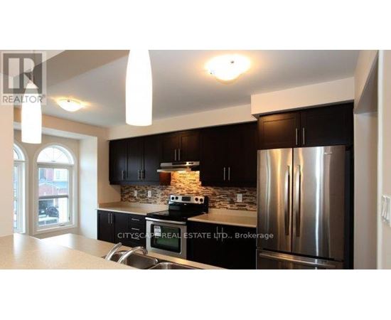 A modern kitchen with a stainless steel refrigerator and black cabinets.