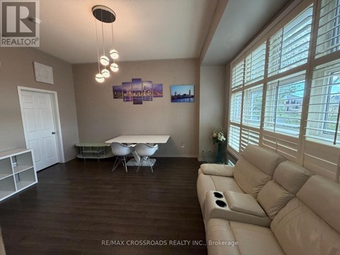 A living room with a couch, table, and chairs.