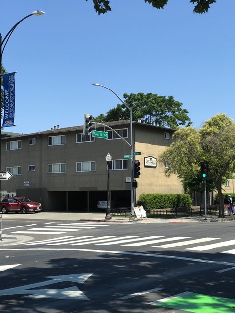 A street corner with a traffic light and a building in the background.