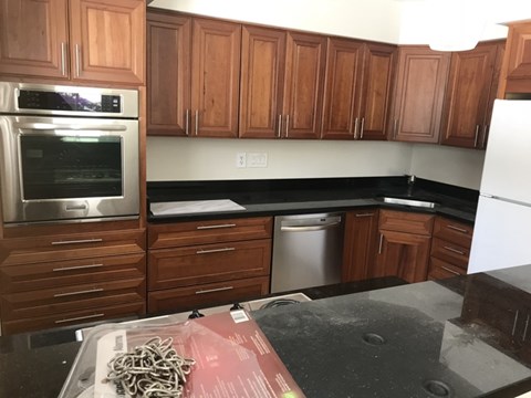 A kitchen with wooden cabinets and a white fridge.