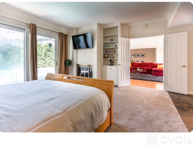 A bedroom with a large bed and a flat screen TV mounted on the wall.