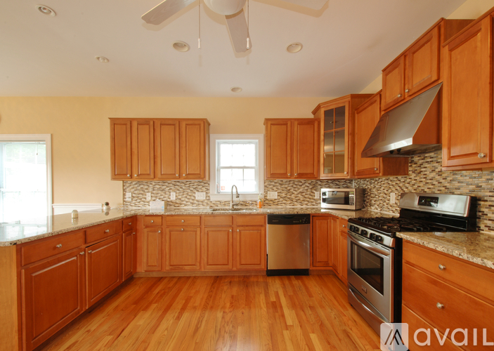 A kitchen with wooden cabinets and a stone backsplash.