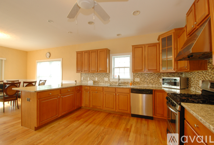 A kitchen with wooden cabinets and a stainless steel dishwasher.