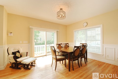 A dining room with a wooden table and chairs.