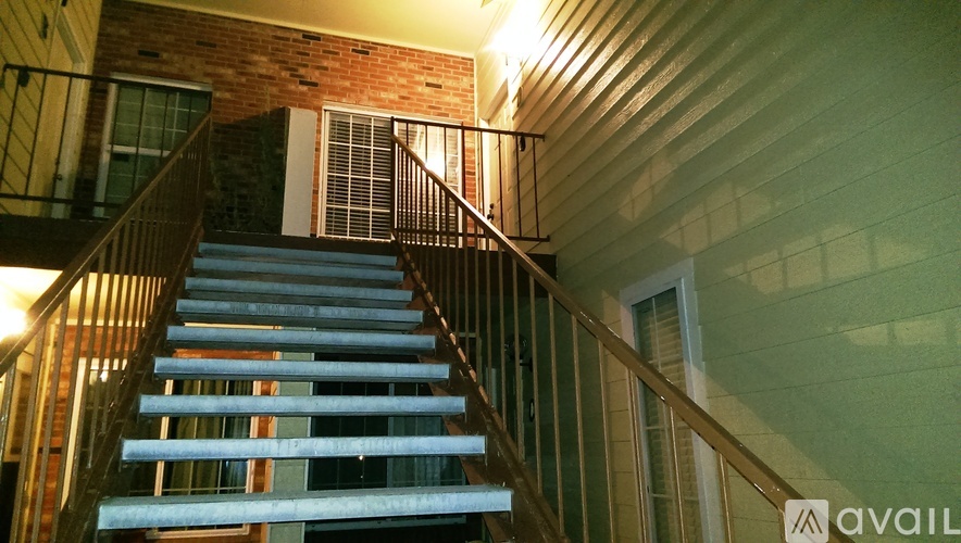 A staircase with a metal railing and wooden steps.