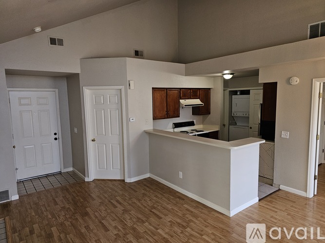 A white reception desk in a room with wooden floors and white walls.