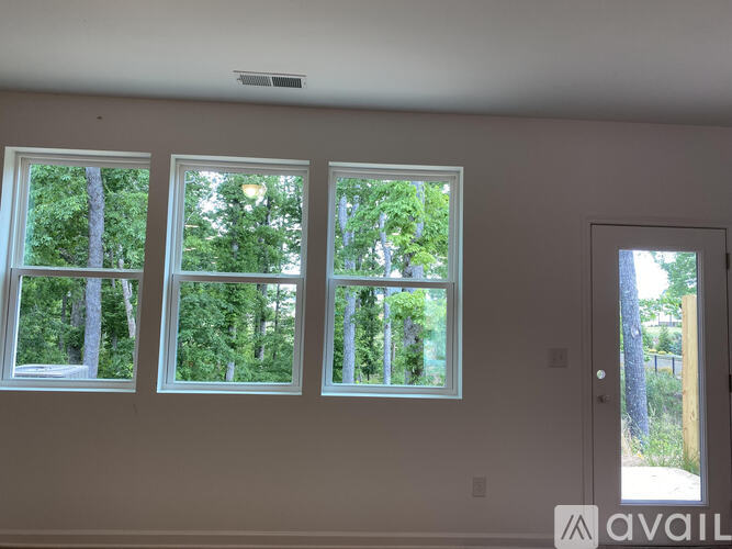 Three windows in a room with trees visible outside.