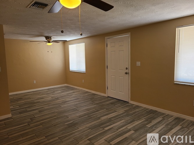A room with a ceiling fan and a door.
