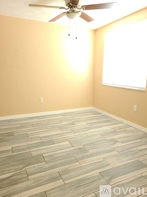 A room with a ceiling fan and a window.