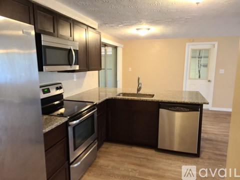 A kitchen with a stainless steel refrigerator, microwave, oven, and dishwasher.