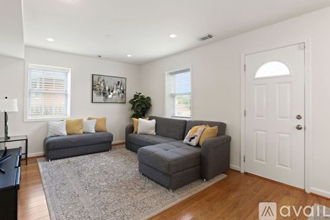 A living room with grey couches and a white door.