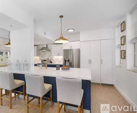 A kitchen with white chairs and a white counter.