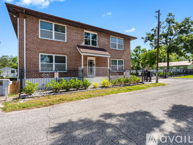 A brick house with a fence in front of it.