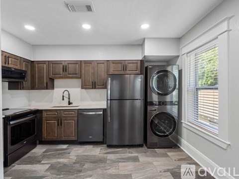 A kitchen with a black refrigerator and a black dishwasher.