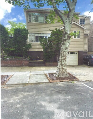 A tree in a planter box in front of a house.