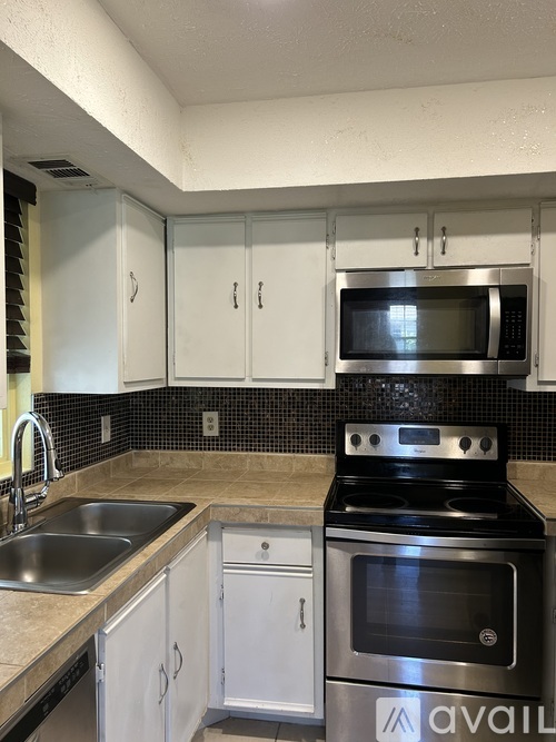 A kitchen with a stove top oven and cabinets.
