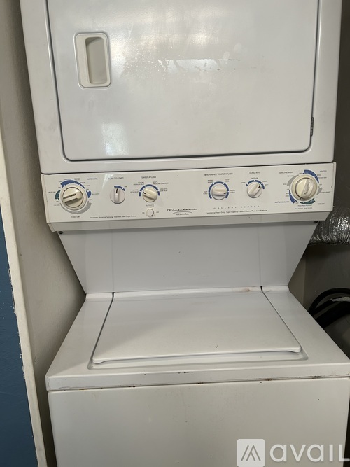 A white oven with a door and four knobs on the front.