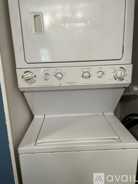 A white oven with a door and four knobs on the front.