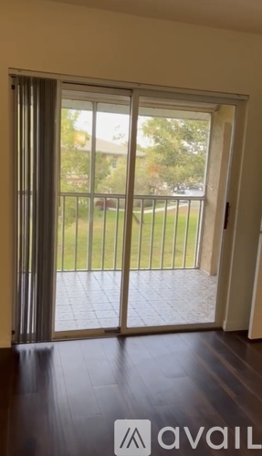 A patio door with a view of a lawn and trees.
