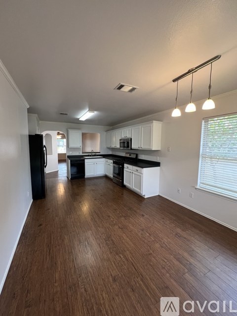 A kitchen with white cabinets and black appliances.