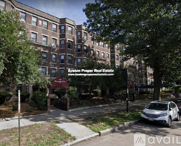 A street view of a building with the sign "Boston Property Real Estate" and a website address.